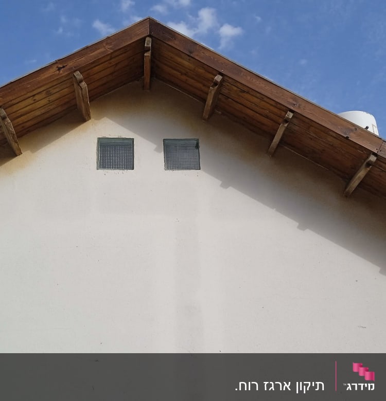 גג עץ משופע עם קורות עץ ופתחי אוורור